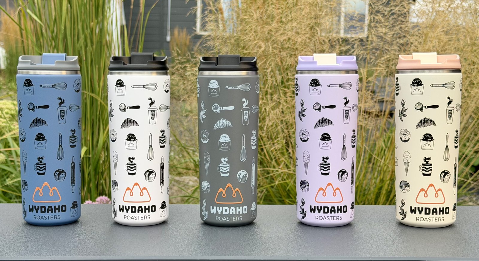 All five Wydaho Roasters tumbler colors side by side: light blue, white, grey, lavender and cream